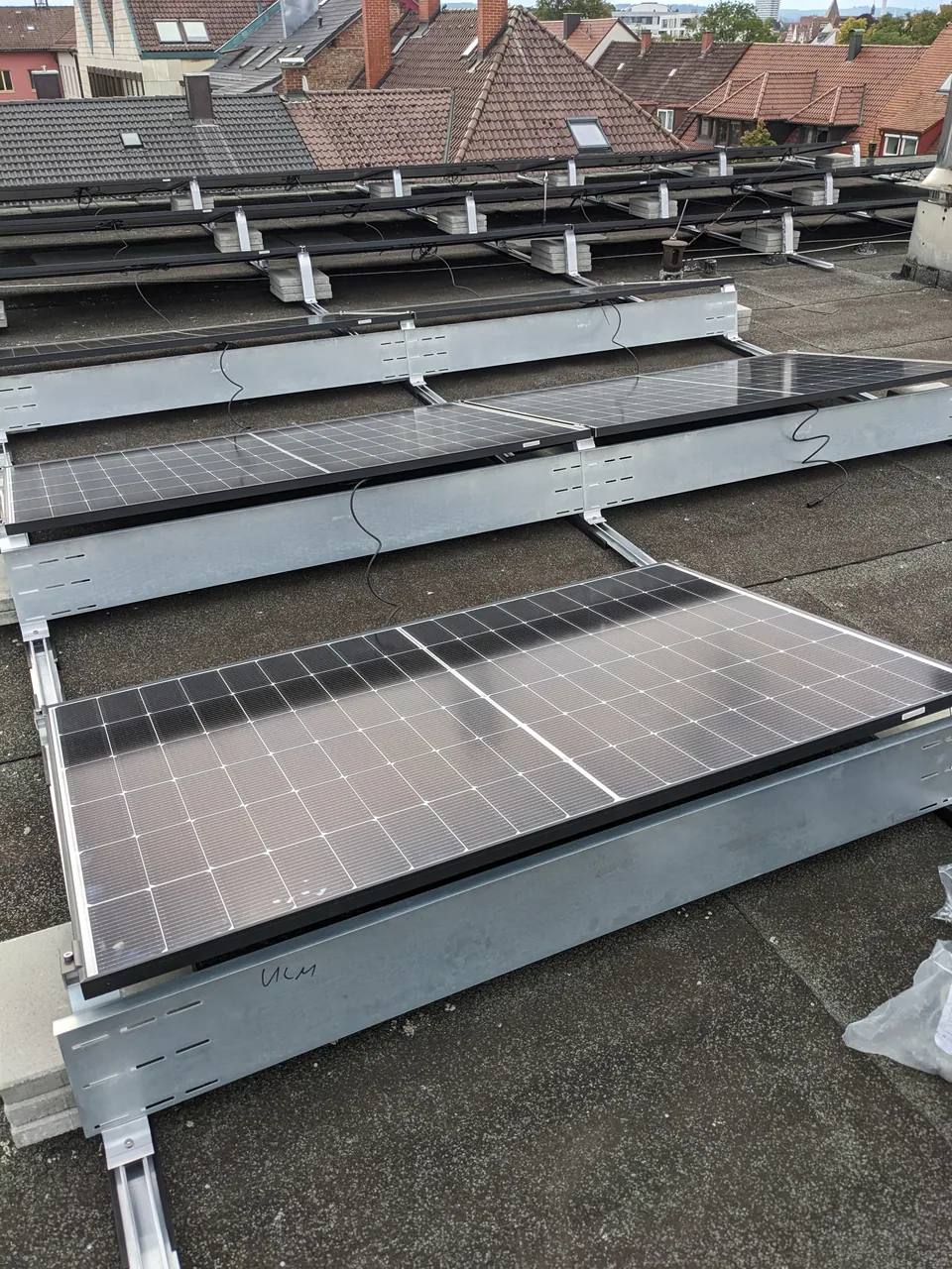 Fachkräfte bei der Montage von Photovoltaikmodulen auf einem Dach